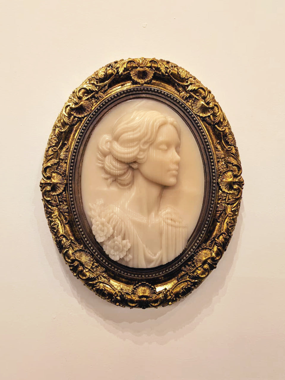 Emily Brontë Cameo — resin and 24k gold leaf by JoCa: an ivory cameo of a woman with swept-up hair in three-quarter view, in an ornate gold oval frame